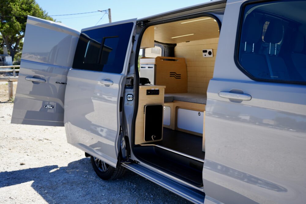 Aménagement modulable installé dans un van avec accès latéral