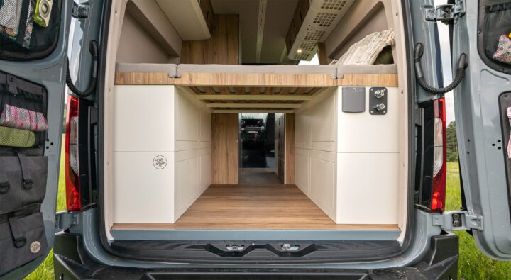 Modules Moon Garage Van Der Moon installés sous un lit fixe dans un fourgon aménagé.